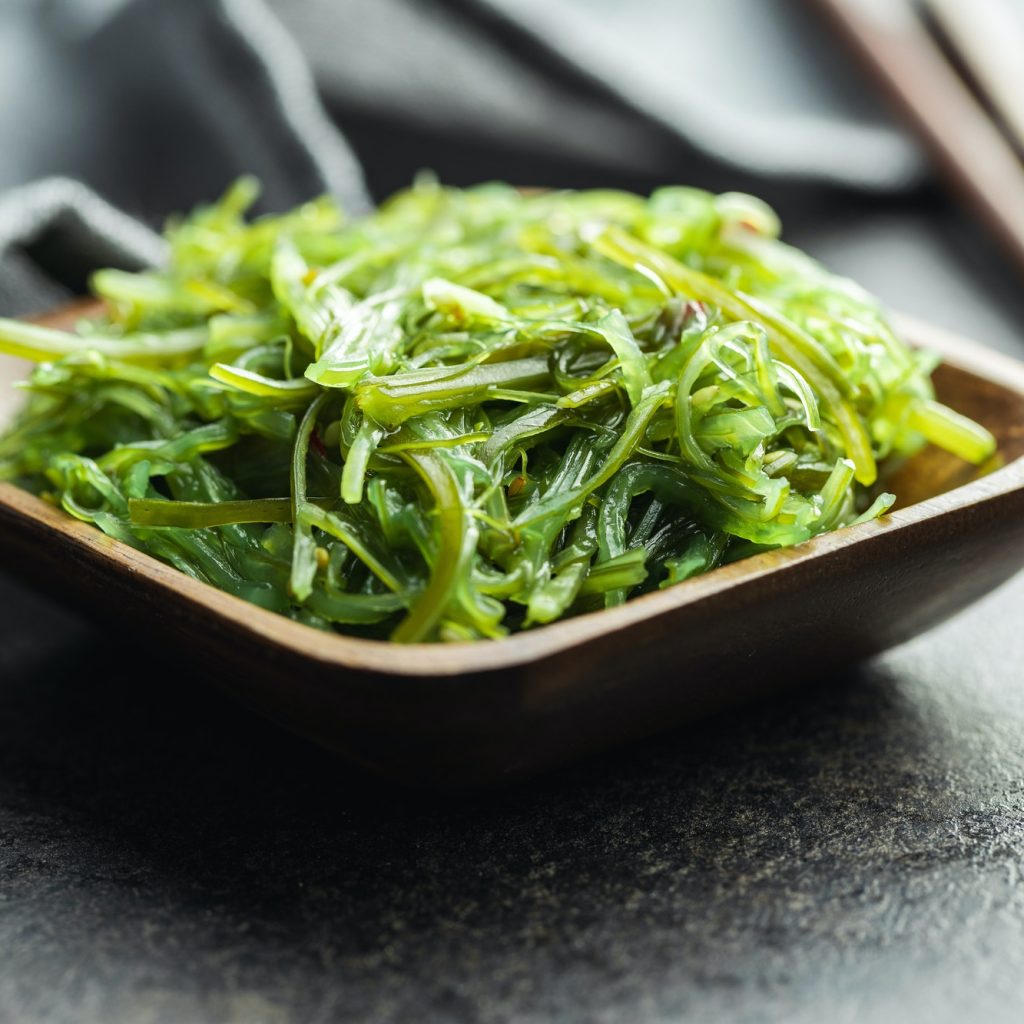 Green wakame. Seaweed salad in wooden bowl.